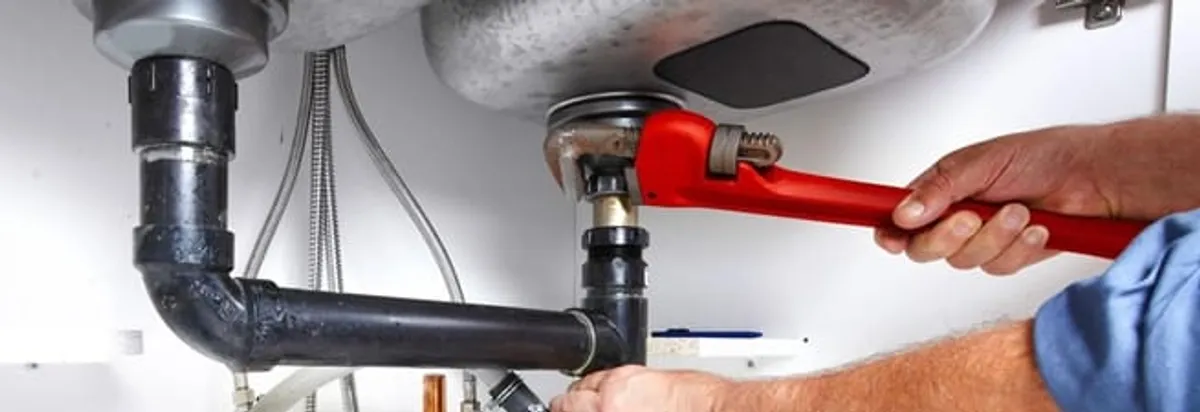 Garbage disposal repair technician tightening the sink drain and disposal connection in Aurora, CO